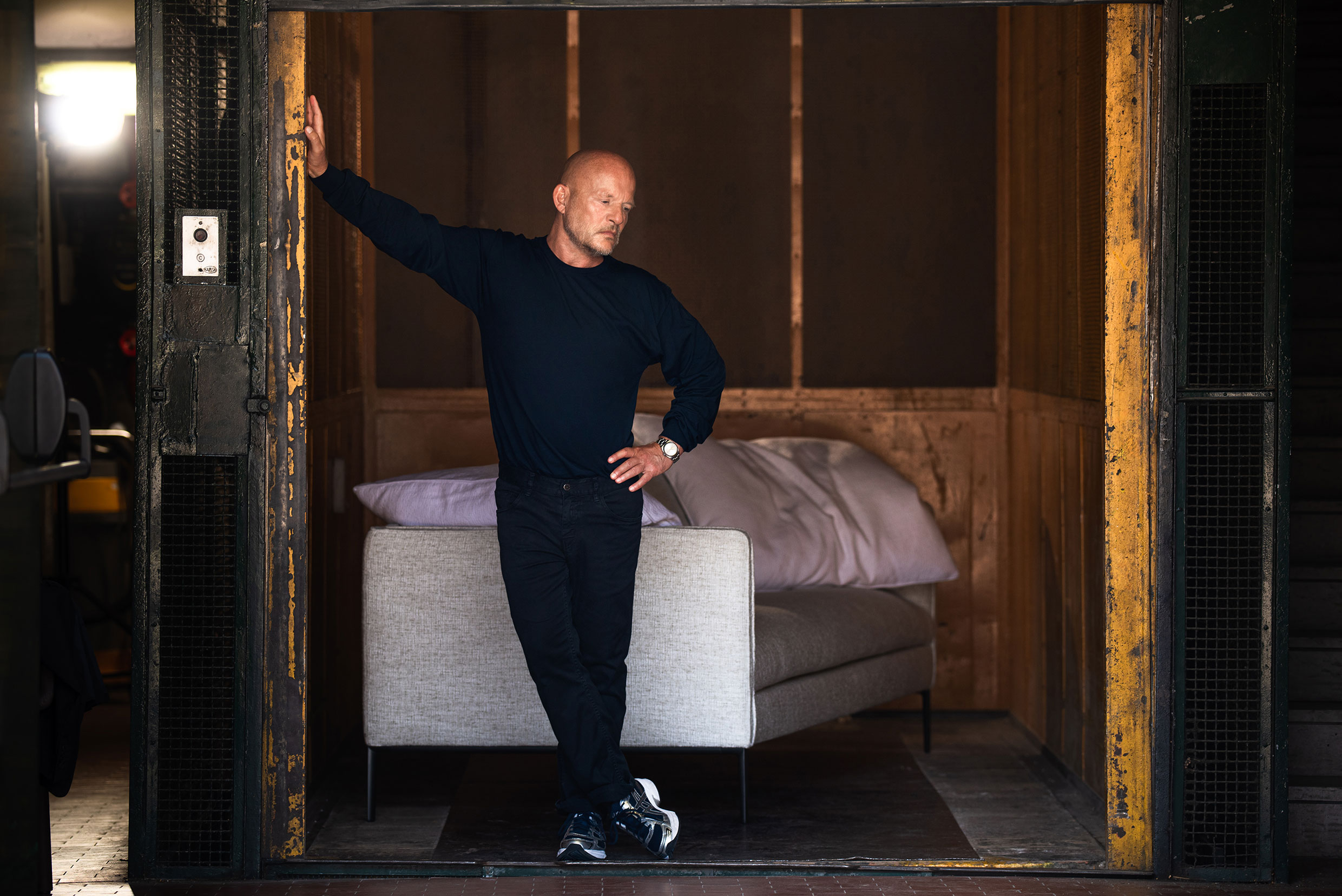 Vincent Van Duysen in the "goods" lift with the Paul sofa Ph. Jeff Burton, from Molteni Mondo by Rizzoli NY, 2024