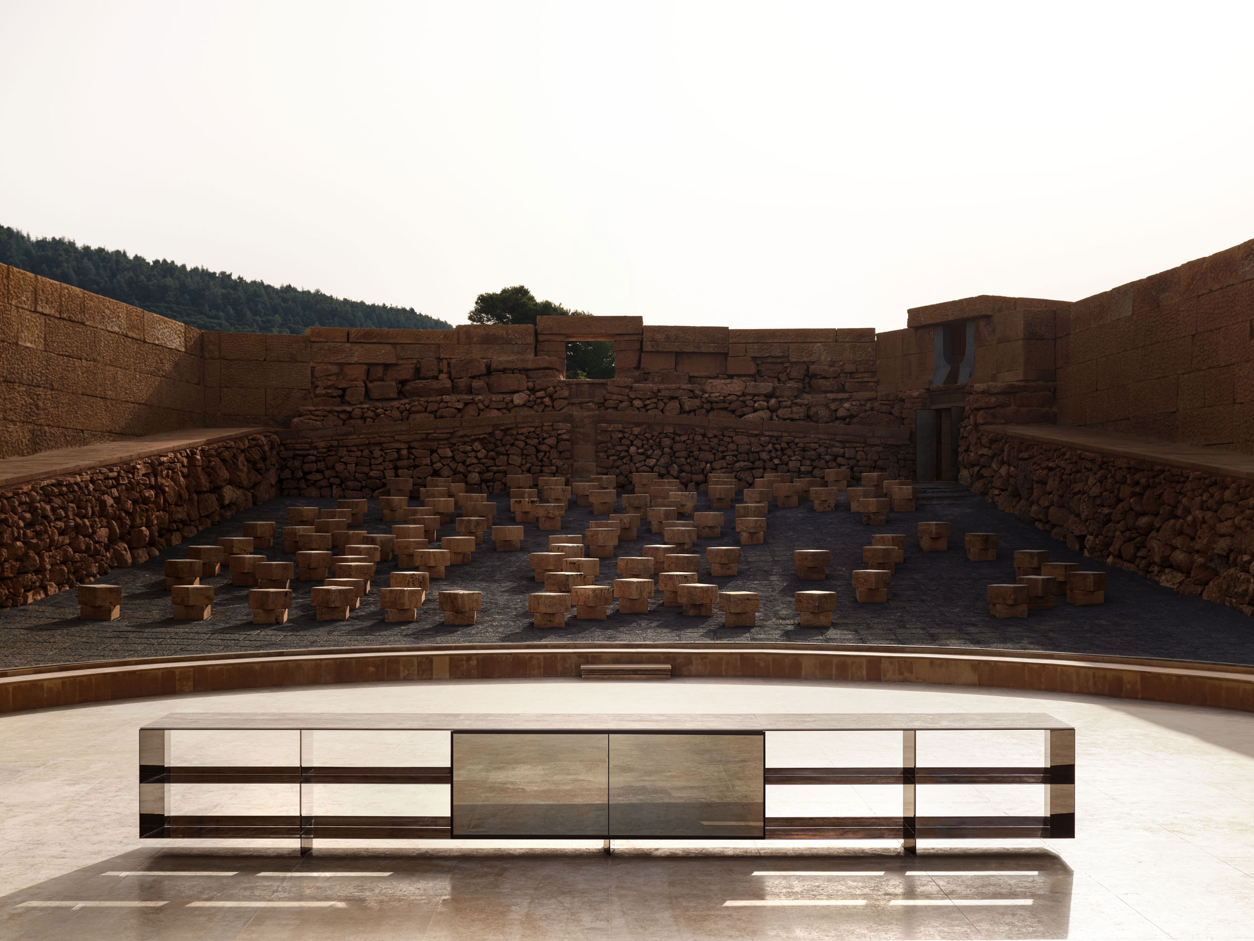 Credenza with black chrome aluminum structure, travertine top and hinged mirrored central glass doors – ph. Alberto Strada