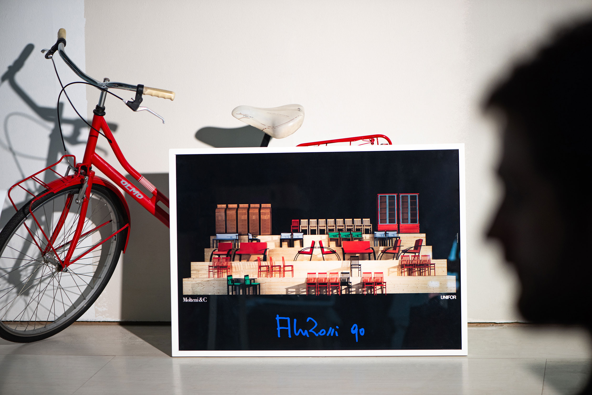 Manifesto installato al Salone del Mobile nel 1990 con arredi disegnati da Aldo Rossi per Molteni&C e UniFor. Foto originale di Mario Carrieri. Foto di Jeff Burton, tratta da Molteni Mondo, Rizzoli NY, 2024.