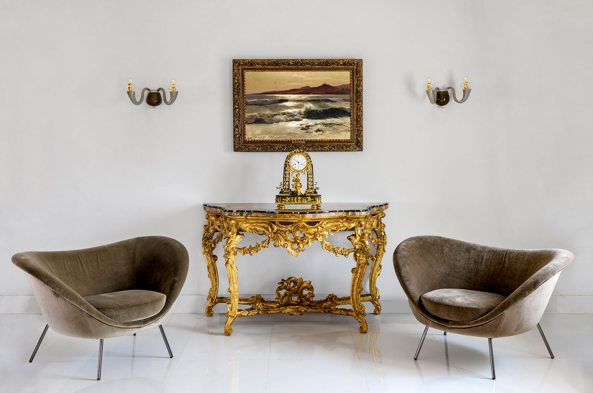 Two design armchairs with golden sideboard